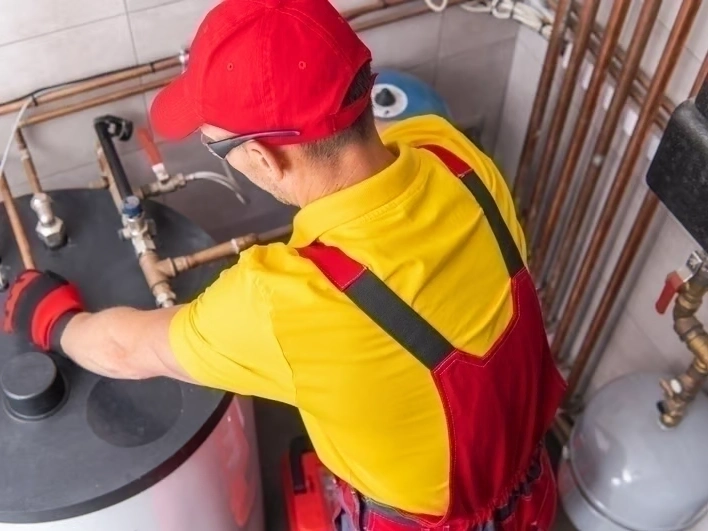 SnoFalls Plumbing LLC technician inspecting a water heater in Auburn